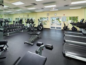 A gym with treadmills, dumbbells, and weight machines.