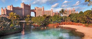 A resort with a large pool, palm trees, and a distinctive archway.