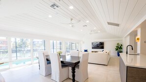 Una cocina moderna con comedor, ventanas amplias y vista a la piscina.