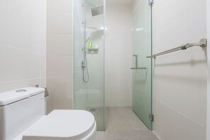 A modern bathroom with a glass shower enclosure, a white toilet, and a glass door. - Cozy Oasis near Ikea TRX Mall King Size Bed 100mb (Kuala Lumpur)