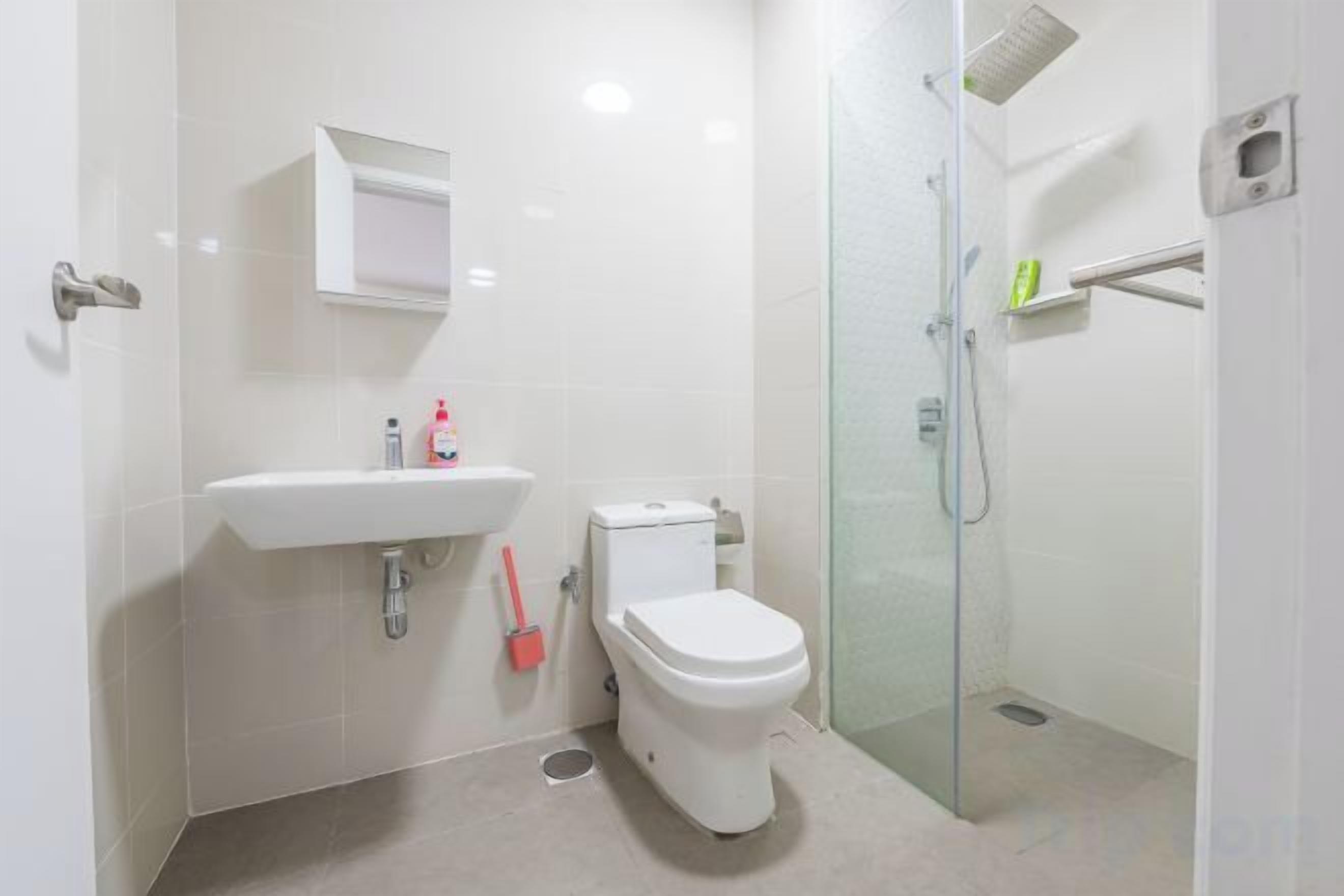 Un bagno moderno con servizi igienici, lavandino e box doccia in vetro.