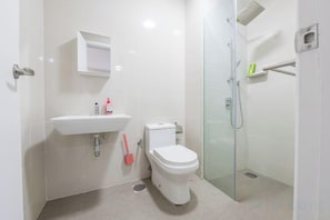 A modern bathroom with a toilet, sink, and glass shower enclosure. - Cozy Oasis near Ikea TRX Mall King Size Bed 100mb (Kuala Lumpur)