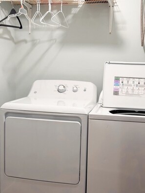 Un lave-linge à chargement frontal doté d’un panneau de commande et d’un sèche-linge placé au-dessus.