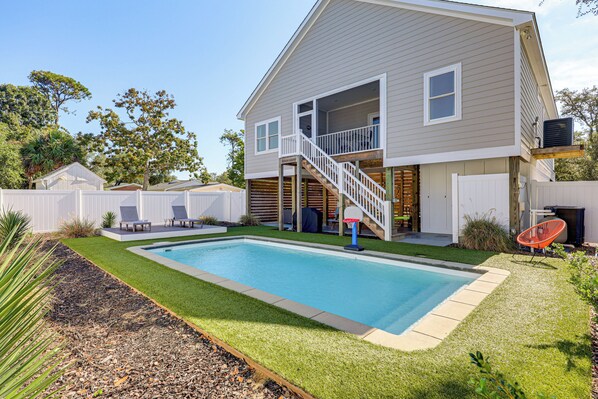 Une maison à deux étages avec une piscine, un patio couvert et une petite terrasse.