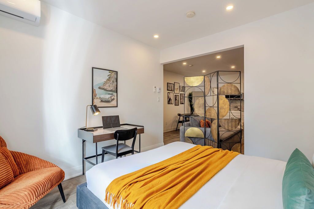 Ein modernes Hotelzimmer mit Bett, Schreibtisch und einer Sitzecke.