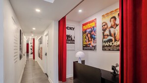 Un corridoio con tende rosse, manifesti e una reception.
