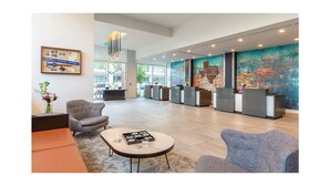 A spacious lobby with a reception desk, seating area, and a large abstract mural on the wall. - Chic Studio Deluxe Hotel Suite in the Heart of Austin (Austin)