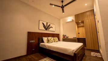Un dormitorio con una cama de madera, un ventilador de techo, aire acondicionado de pared y un armario de madera.