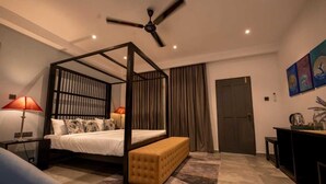 Une chambre à coucher moderne avec un lit à baldaquin, un ventilateur de plafond, un banc et un bureau avec une lampe.