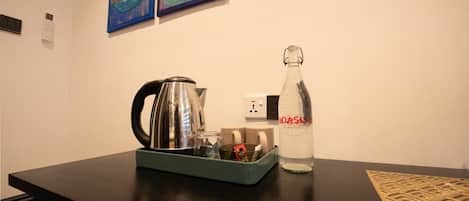 A table with a kettle, a bottle labeled "OASIS," and a tray with various items.