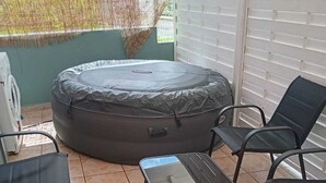 Ein Patio mit einer runden Sitzecke, einem Tisch und zwei Stühlen.