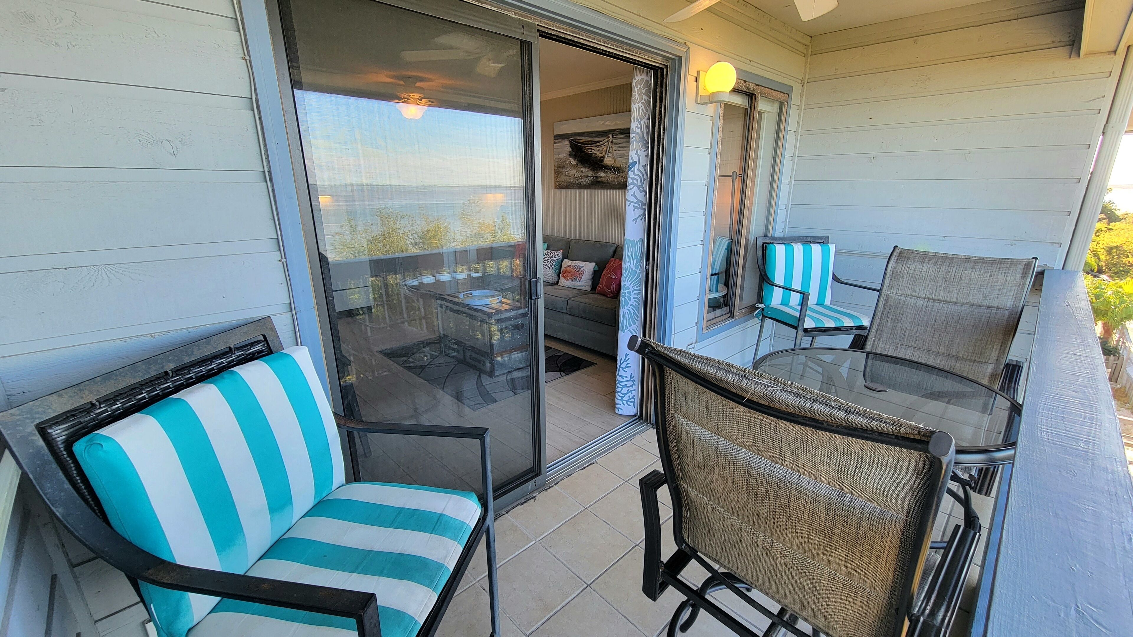 Eine überdachte Terrasse mit einer Glastür, die in einen Wohnbereich führt.