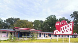 A motel with a red and white sign that reads "Motel of Heart Dixie." - Heart of Dixie Motel Near Auburn AL (Dadeville)