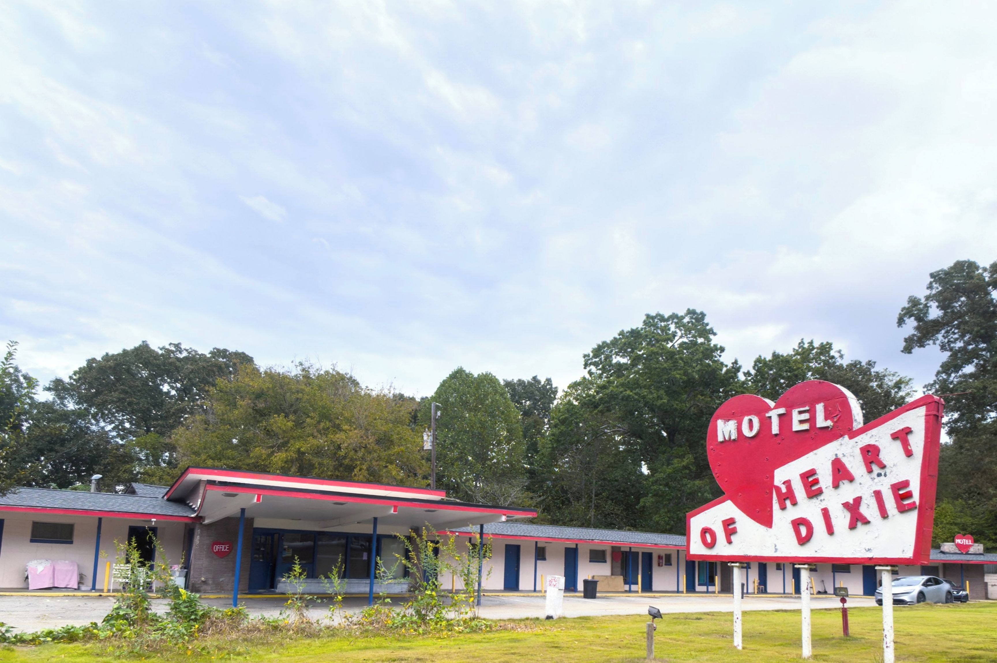Un motel avec une enseigne rouge et blanche sur laquelle on peut lire : « Motel of Heart Dixie ».