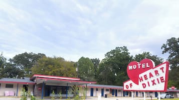 A motel with a red and white sign that reads "Motel of Heart Dixie."