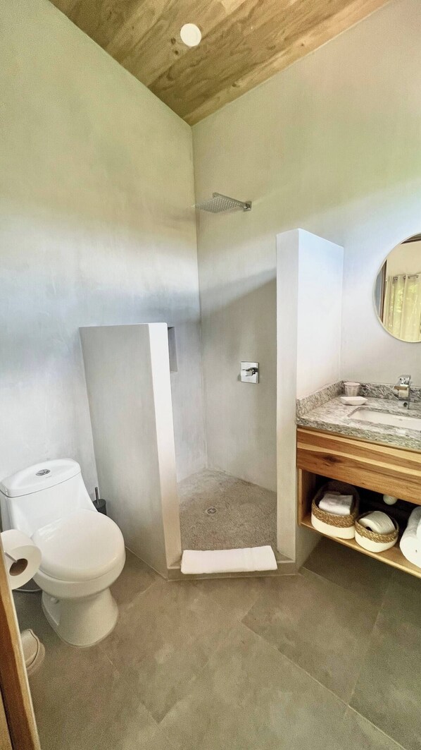 A bathroom with a shower, toilet, and sink.