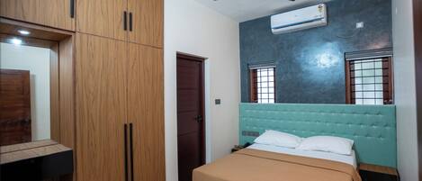 Une chambre à coucher avec un lit, une armoire et un ventilateur de plafond.