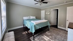 A bedroom with a bed, a ceiling fan, a bench, and a rug. - Waterfront Beaufort Home - 3 Miles to Parris Island & Downtown! (Beaufort)