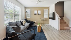 A living room with a sofa, coffee table, and a staircase leading to a second floor.