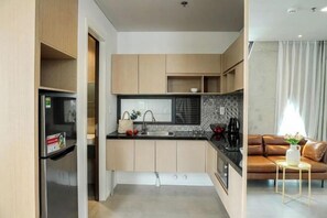 Una cocina moderna con armarios de madera, encimera negra y horno empotrado.