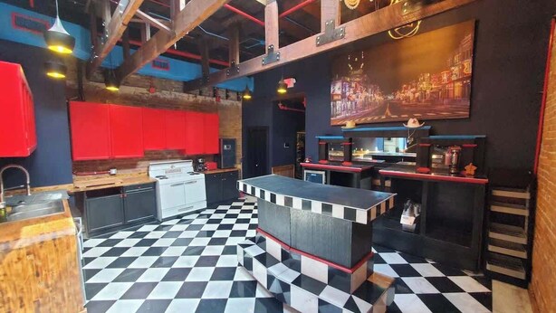 A bar area with a checkered floor, a bar counter, and a red cabinet. - Broadway Penthouse: Stadium View (Nashville)