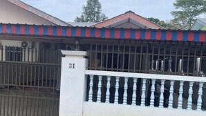 Edifici residencial amb entrada tancada per reixa, número '31' a la porta i un balcó amb barana blanca.