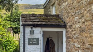 A quaint stone cottage with a sign reading "GATE HOUSE".