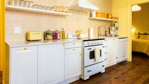 Una cocina con armarios blancos, una estufa y varios utensilios de cocina sobre la encimera.