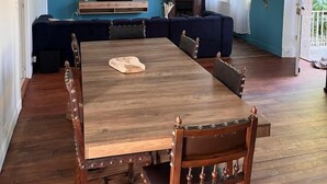 Un comedor con mesa y sillas de madera, un conjunto de sofás y una chimenea.