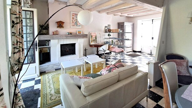 Una sala de estar con chimenea, un sofá, una mesa de centro y una estantería.