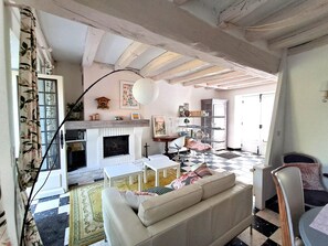 A living room with a fireplace, a sofa, a coffee table, and a bookshelf.