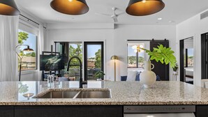A modern kitchen with granite countertops, a built-in dishwasher, and a large window offering a view of the outdoors. - 2 Condos-8 Min to Broadway-Balcony-5 King Beds (Nashville)