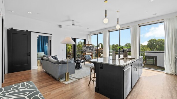 A modern kitchen with a central island, large windows, and a view of the outdoors. - 2 Condos-8 Min to Broadway-Balcony-5 King Beds (Nashville)