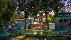 Une propriété au bord du lac, dotée d’un quai, d’une terrasse couverte et d’une maison avec un porche.