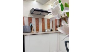 A kitchen with a modern design, featuring a white countertop, a built-in oven, and a backsplash with vertical stripes.