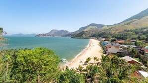 A coastal town with a beach, houses, and hills in the background. - Loft com Varanda e Vista Para o mar em Mangaratiba (Mangaratiba)