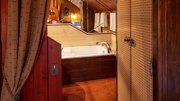A wooden interior with a bathtub, a mirror, and a towel rack.