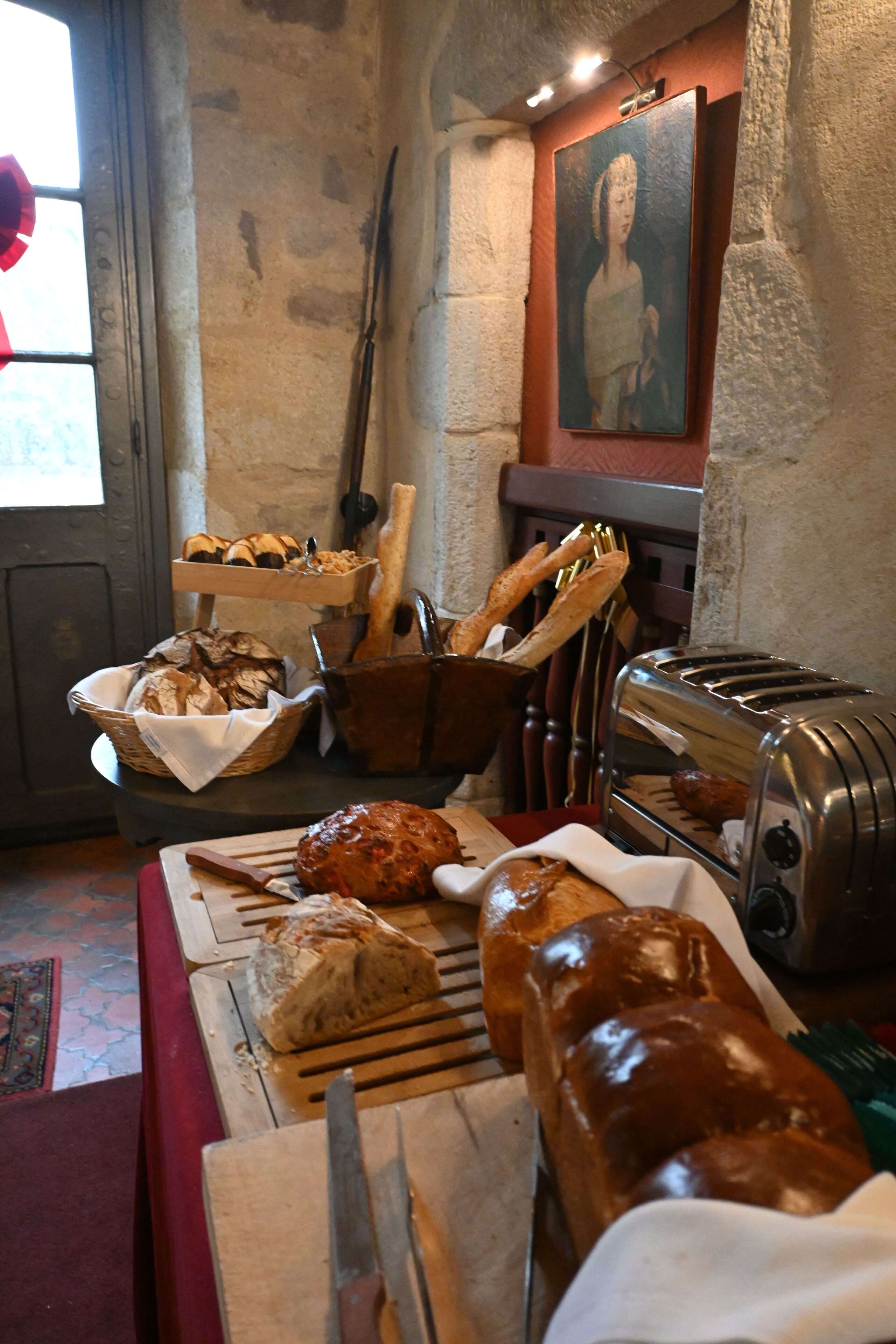 A breakfast buffet with bread, pastries, and a toaster.