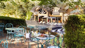 An outdoor patio with a pool, lounge chairs, and a dining table with chairs. - Château de Codignat (Bort-l'Étang)