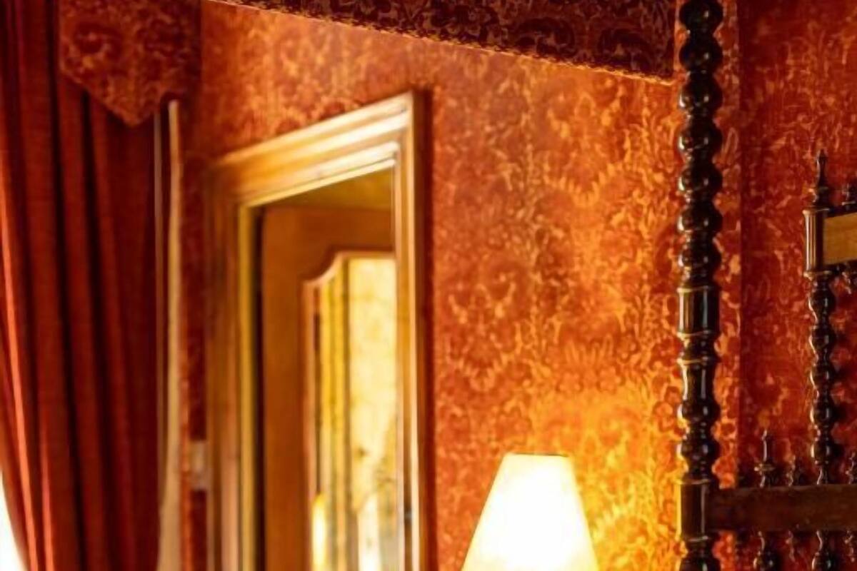 Una habitación de hotel con una cama, una lámpara y una puerta.