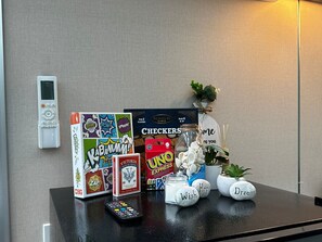 A table with a remote control, a board game, a jar, and decorative stones. - Studio Capsule House in Parry Sound #31 (Parry Sound)