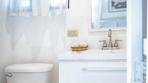 A bathroom with a toilet, a sink, and a mirror.