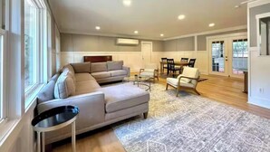 A spacious living room with a large sectional sofa, a dining table with chairs, and a small side table. - 1 Mile to Parris Island - 3BR Beaufort Home - Sleeps 6 (Beaufort)