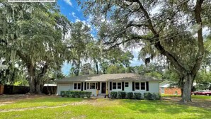 A single-story house with a front porch, surrounded by mature trees and a well-maintained lawn. - 1 Mile to Parris Island - 3BR Beaufort Home - Sleeps 6 (Beaufort)