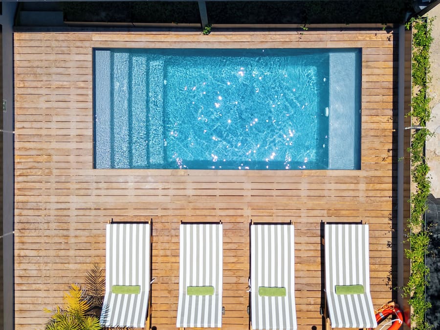 Una piscina al aire libre, sillones reclinables de piscina