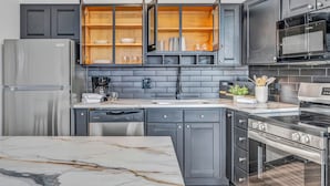 A modern kitchen with grey cabinetry, a built-in oven, and a marble countertop. - City-view, Free Parking, 24/7 Gym (Cleveland)