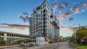 A multi-story building with a modern architectural design, featuring large windows and a prominent corner structure. - City-view, Free Parking, 24/7 Gym (Cleveland)