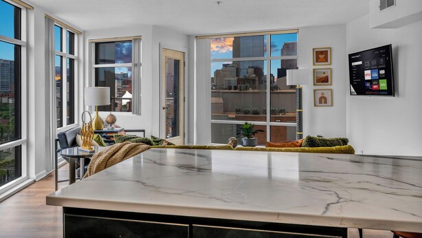 A modern kitchen with large windows, a marble countertop, and a city view. - City-view, Free Parking, 24/7 Gym (Cleveland)