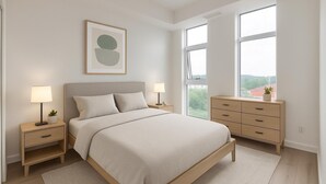 Een slaapkamer met een groot bed, twee nachtkastjes, een kaptafel en een raam met uitzicht.