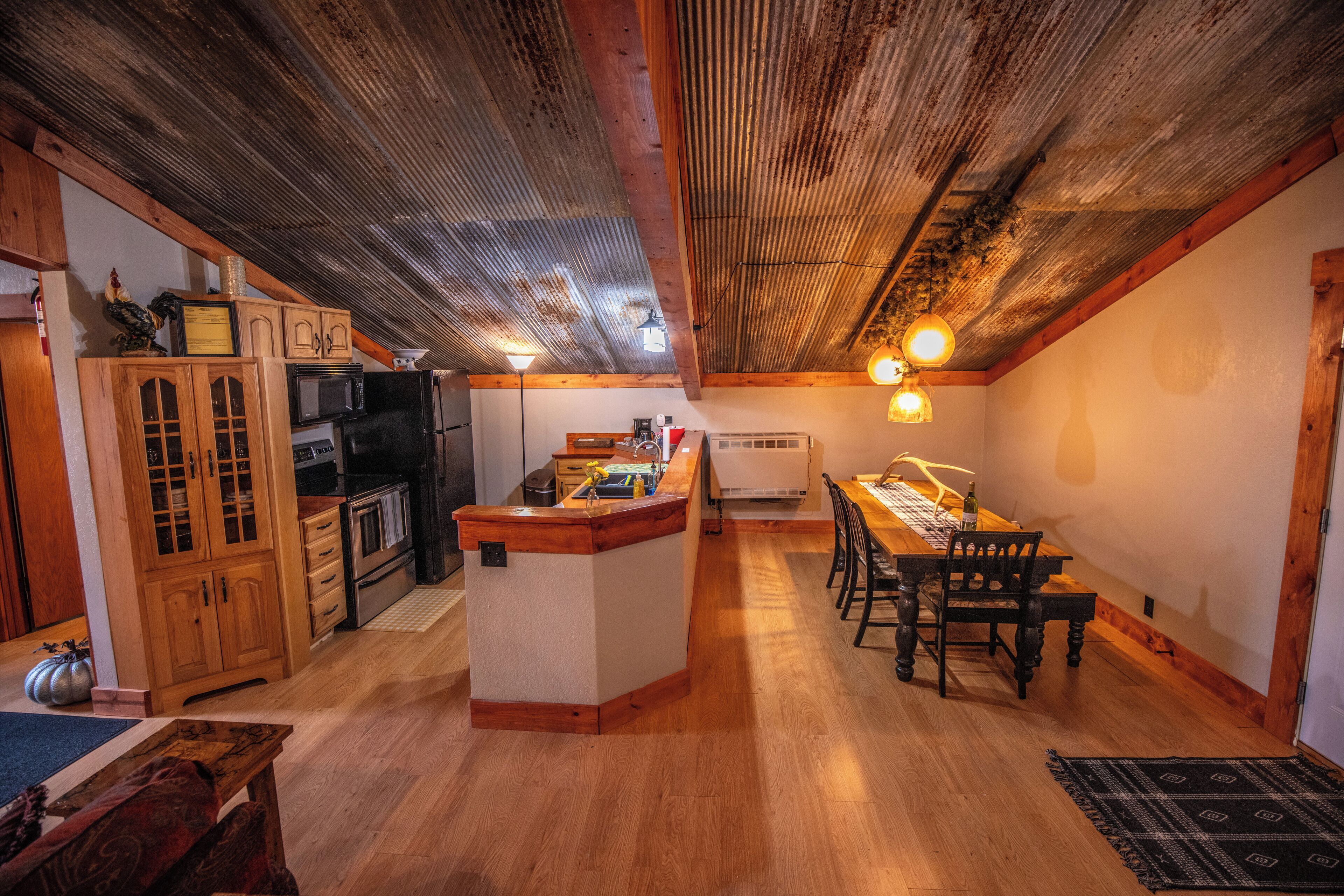 A cozy kitchen with wooden cabinets, a dining table, and a central island.